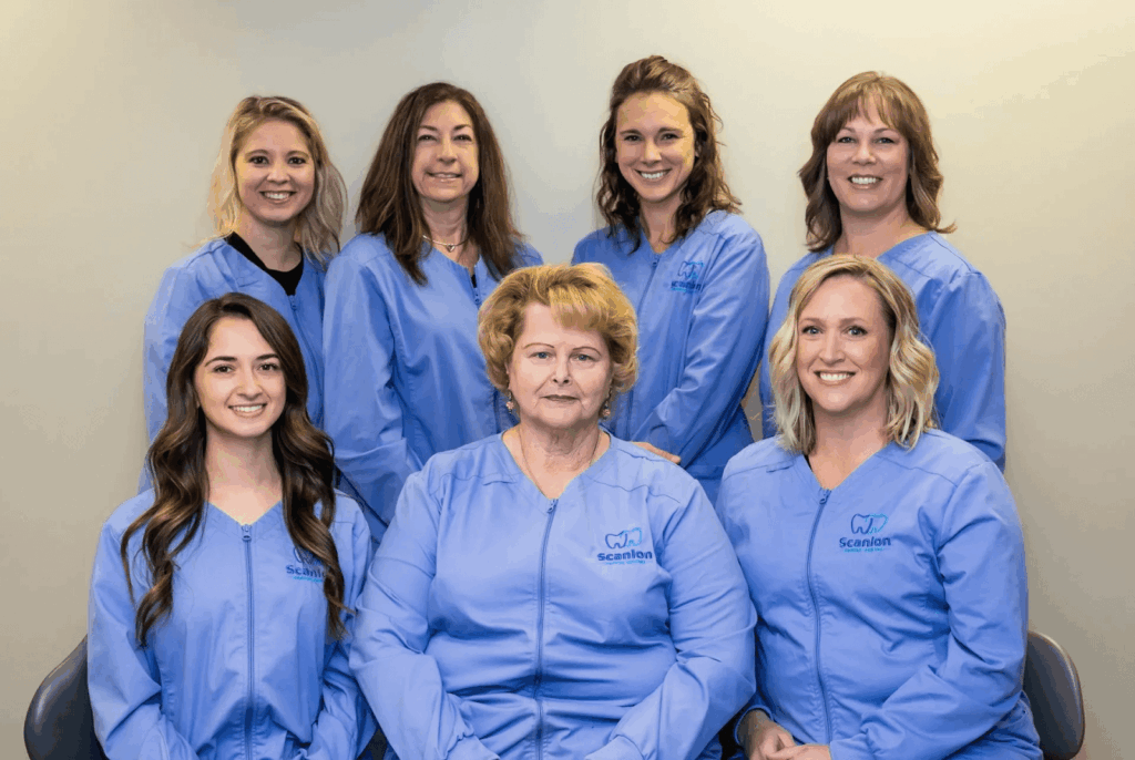 Full dental care team standing together in a professional dental office setting