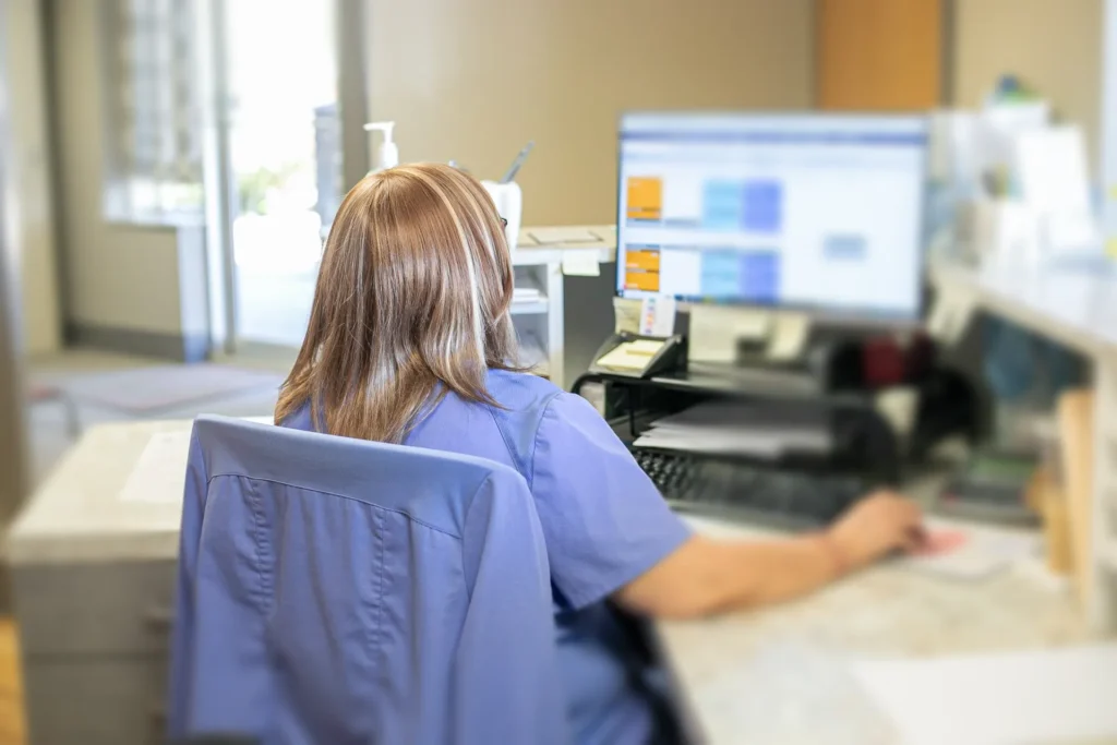 Dental front desk staff working at computer in clinic reception