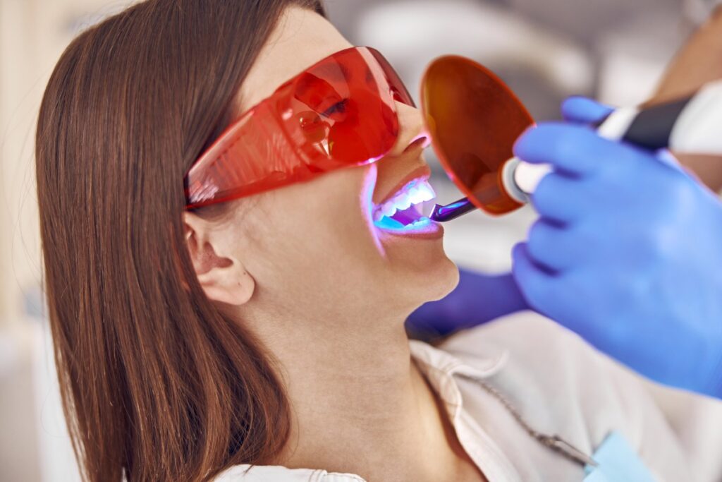 Dental professional using a curing light during a dental procedure